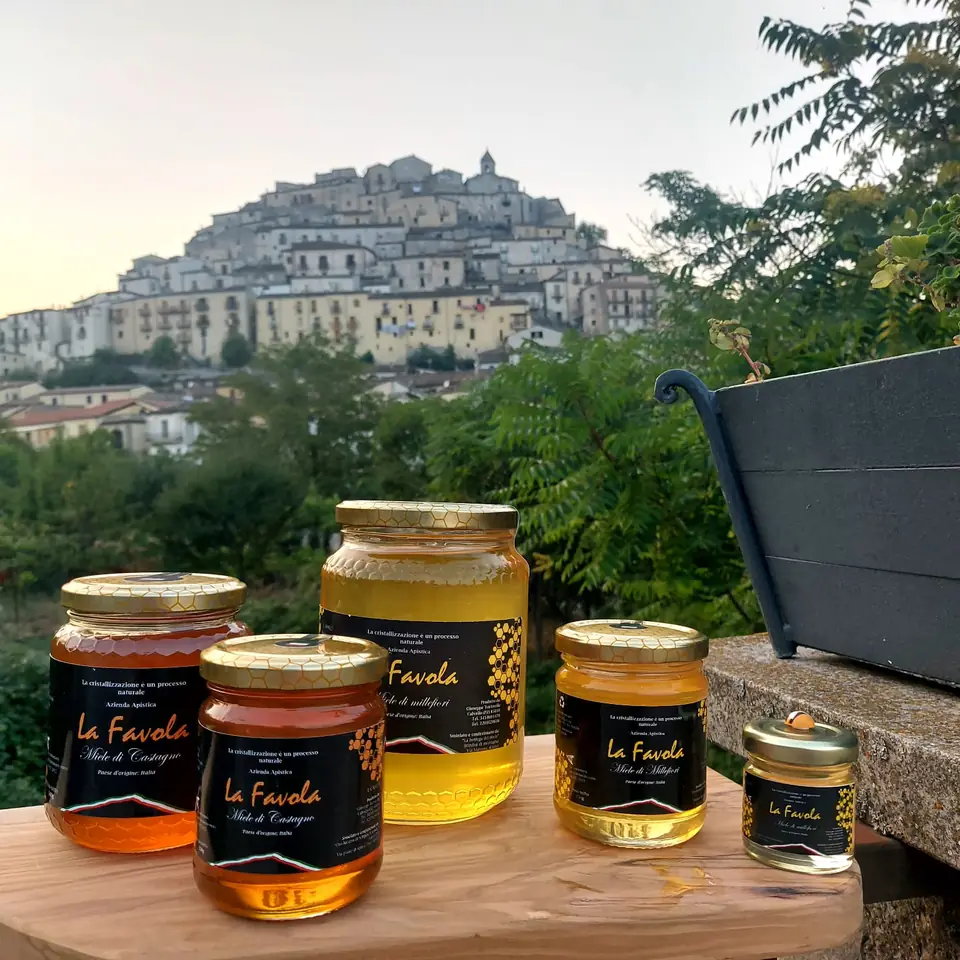 I mieli La Favola su un muretto, con il paese di Calvello sul suo colle alle spalle